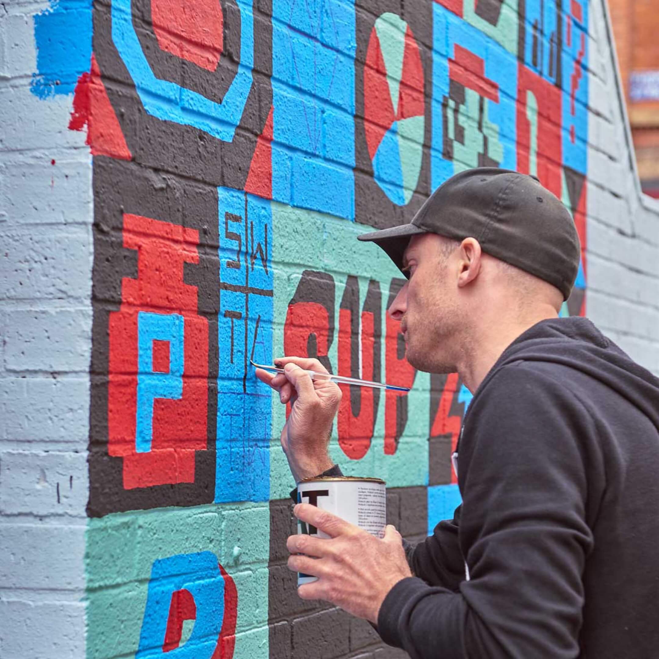 Man painting a mural in Manchester