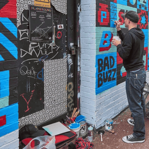 Photos of Paul working on mural in Manchester